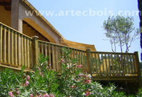 artecbois en bordure de la terrasse surelevee en lames de bois, rambarde avec piliers en bois et barreaux en bois, la rampe en bois est realisee sur mesure